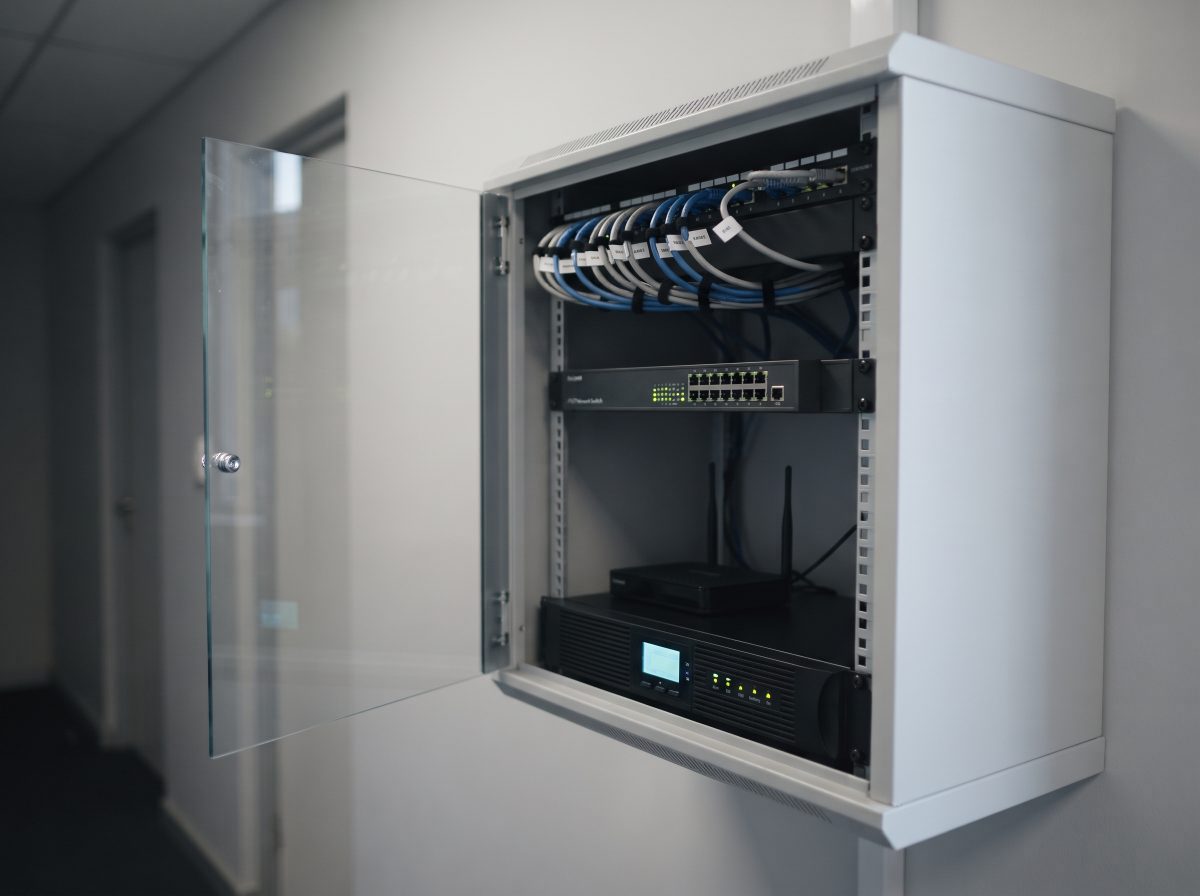 Office network cabinet with PoE switch, router and UPS backup running during a power cut
